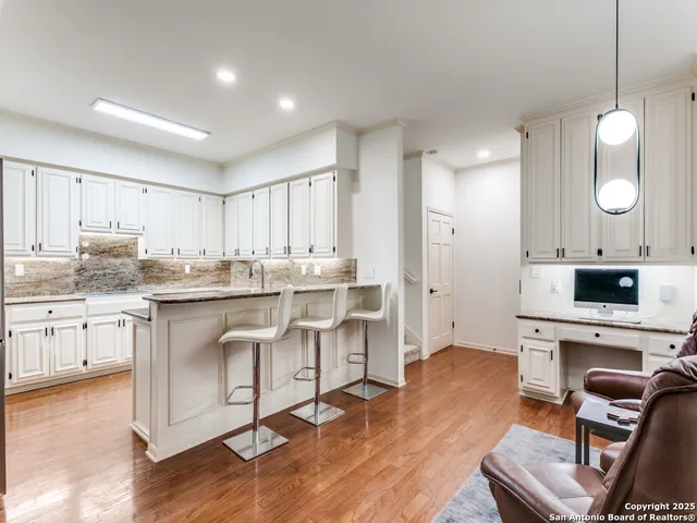 a kitchen with white cabinets and appliances