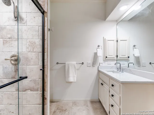 a bathroom with a double vanity sink a mirror and shower