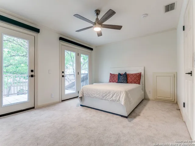 a spacious bedroom with a large bed and two large window