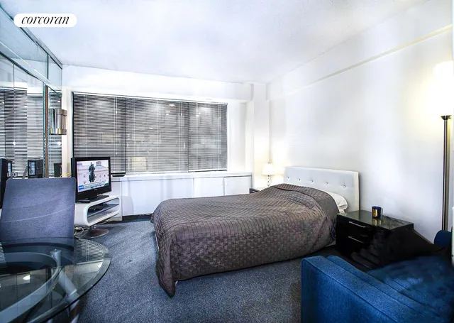 a bedroom with a bed flat screen tv and a large window