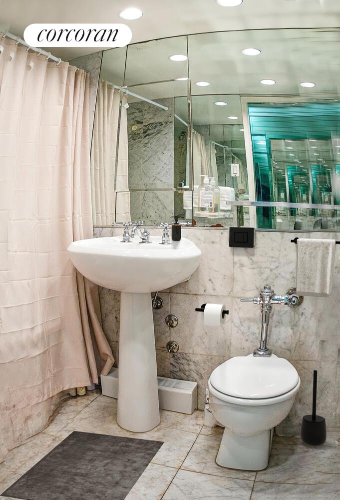 210 East 47th Street, Unit 8G Manhattan, NY 10017 - Photo 5 of 6 a bathroom with a toilet sink and mirror