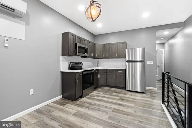 a kitchen with kitchen island a refrigerator and a stove top oven