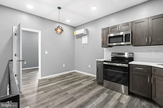 a kitchen with stainless steel appliances granite countertop a stove microwave and refrigerator