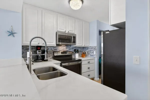 a kitchen with a refrigerator stove and sink