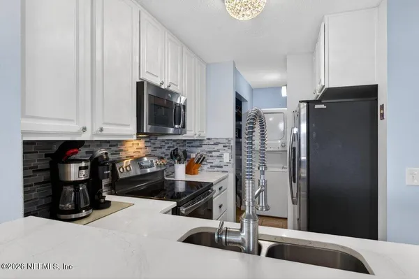 a kitchen with refrigerator and window