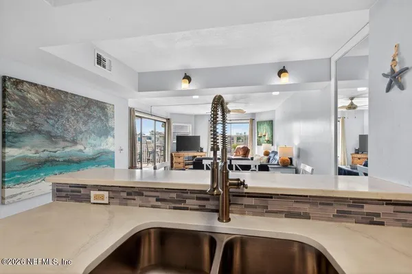a view of center island with kitchen island sink stove and living room view