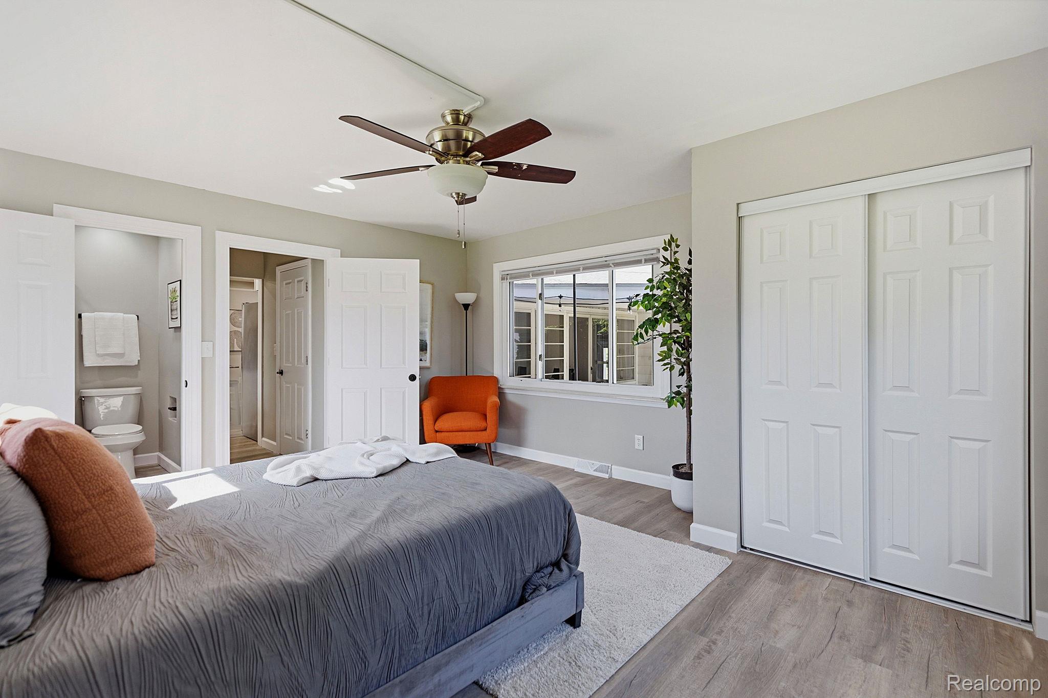8710 32 Mile Road Washington, MI 48095 - Photo 23 of 60 Spacious room featuring wood-finish flooring, a ceiling fan with integrated lighting, and multiple windows
