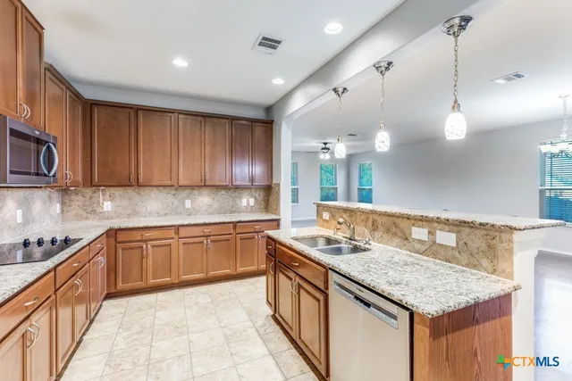 a kitchen with kitchen island granite countertop a sink and stove
