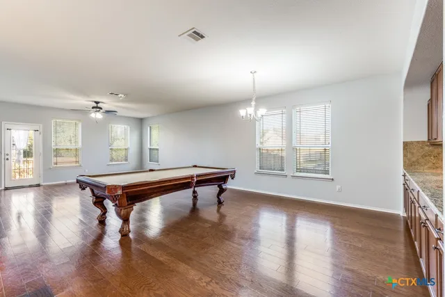 a room with pool table and windows