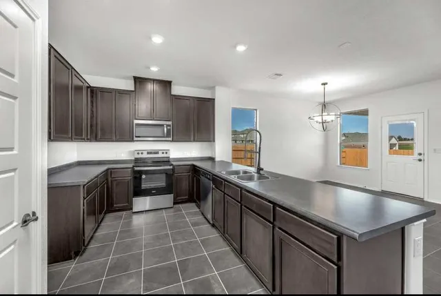 a kitchen with kitchen island granite countertop a sink counter top space appliances and cabinets