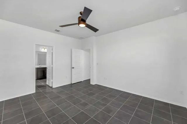 an empty room with a ceiling fan and bathroom