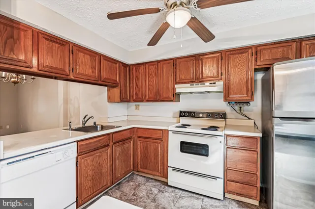 a kitchen with stainless steel appliances granite countertop a stove sink and refrigerator