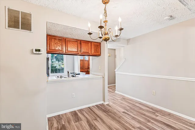 a view of a room with wooden floor and chandelier