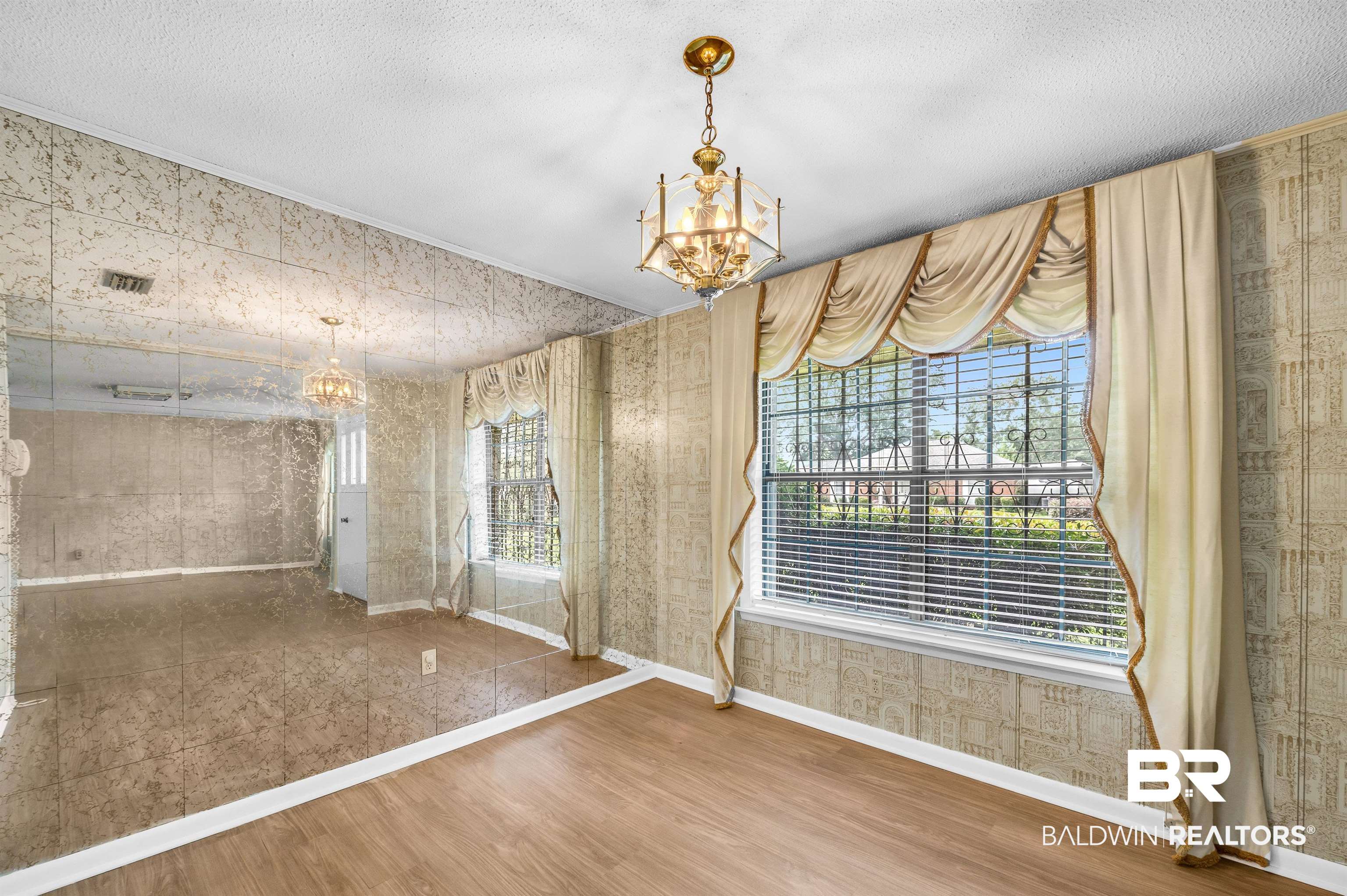610 East Walker Avenue Foley, AL 36535 - Photo 14 of 38 Unfurnished dining area featuring a chandelier, wood finished floors, a textured ceiling, and wallpapered walls