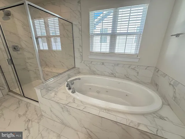a white bath tub sitting in a bathroom next to a window