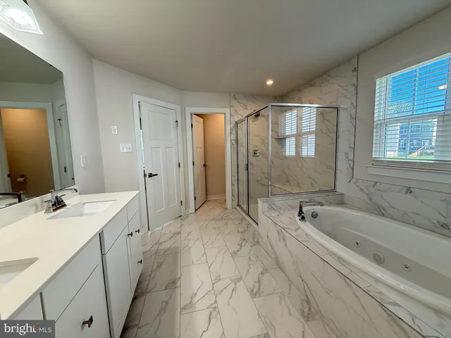 a spacious bathroom with a bathtub sink and mirror
