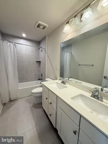 a bathroom with a double vanity sink toilet and shower
