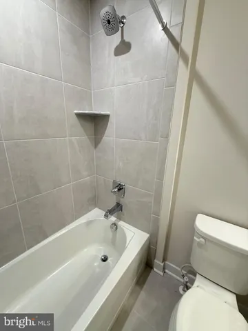 a white toilet sitting next to a bath tub and a shower