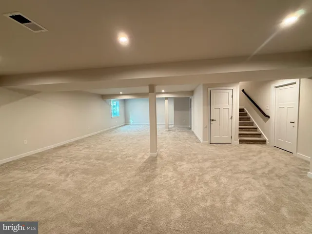 an empty room with wooden floor and stairs