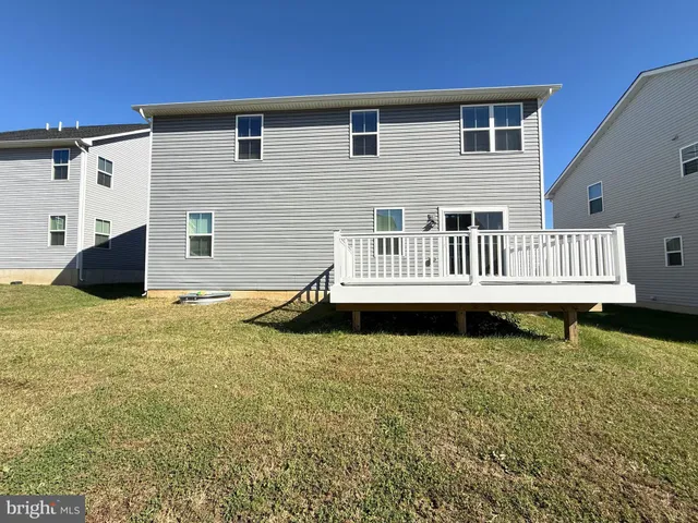 a view of a house with backyard and deck