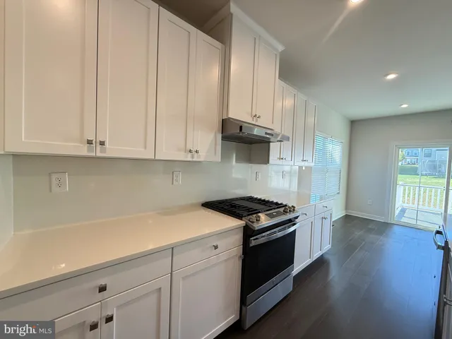 a kitchen with granite countertop white cabinets and black appliances