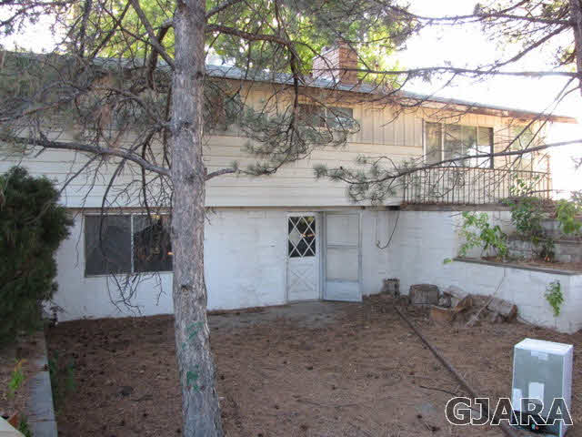 998 21 Road Grand Junction, CO 81505 - Photo 2 of 26 a backyard of a house with wooden fence and large trees
