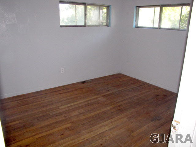 998 21 Road Grand Junction, CO 81505 - Photo 10 of 26 an empty room with wooden floor and windows
