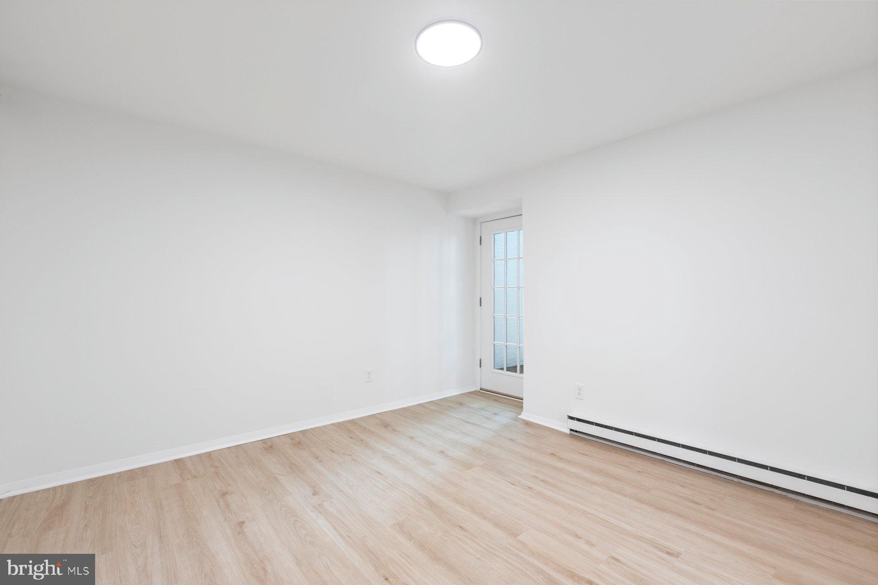 207 South Patrick Street, Unit 104 Alexandria, VA 22314 - Photo 13 of 33 an empty room with wooden floor and windows