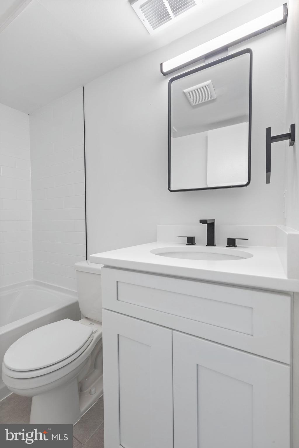 207 South Patrick Street, Unit 104 Alexandria, VA 22314 - Photo 17 of 33 a bathroom with a toilet a sink a vanity and mirror