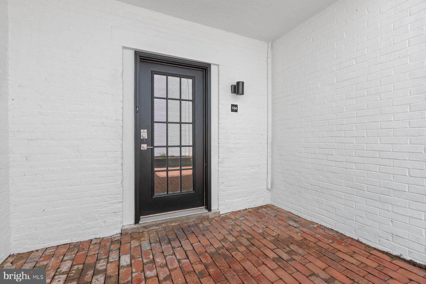 207 South Patrick Street, Unit 104 Alexandria, VA 22314 - Photo 2 of 33 an empty room with wooden floor and windows
