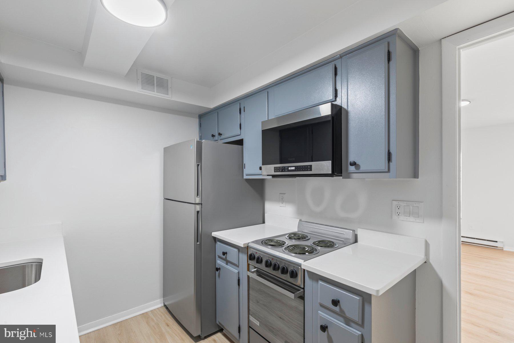 207 South Patrick Street, Unit 104 Alexandria, VA 22314 - Photo 8 of 33 a kitchen with a stove and a microwave