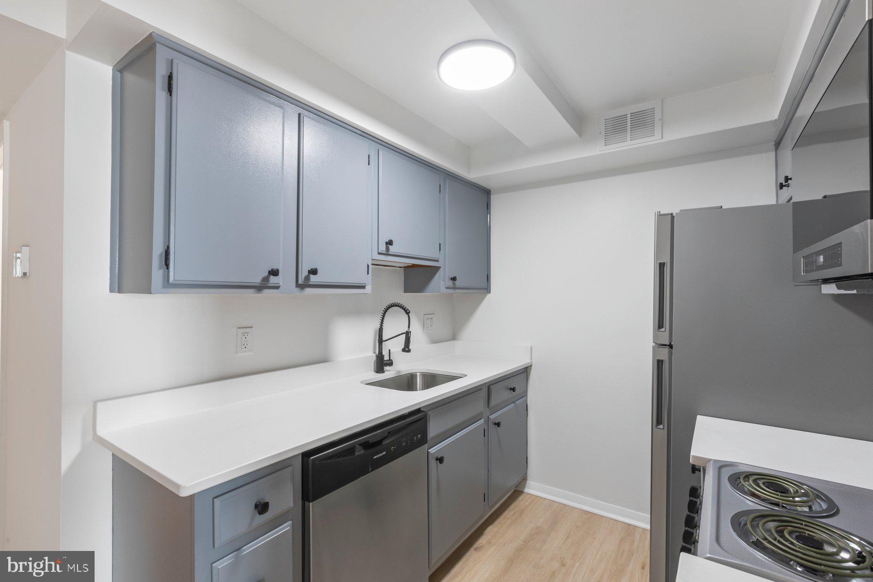 207 South Patrick Street, Unit 104 Alexandria, VA 22314 - Photo 9 of 33 a kitchen with stainless steel appliances a sink dishwasher stove and refrigerator
