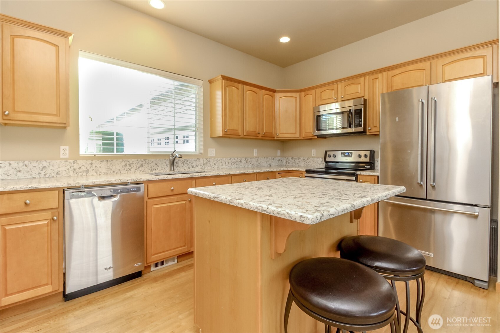 1113 O'Farrell Lane Northwest Orting, WA 98360 - Photo 12 of 36 a kitchen with stainless steel appliances granite countertop a sink stove refrigerator and a window