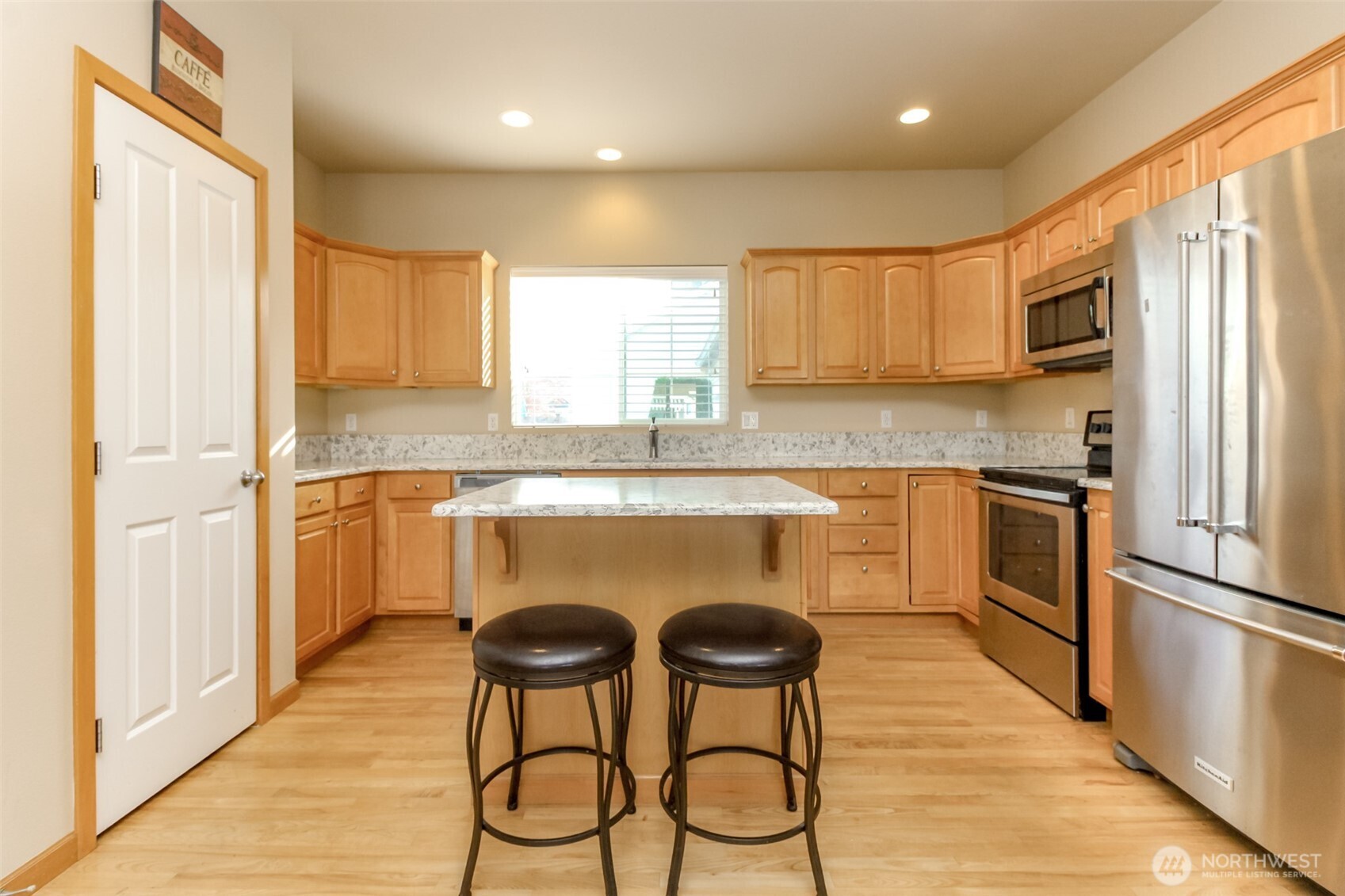 1113 O'Farrell Lane Northwest Orting, WA 98360 - Photo 13 of 36 a kitchen with stainless steel appliances granite countertop a stove a sink dishwasher a refrigerator with white cabinets and wooden floor