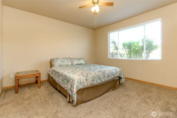 a spacious bedroom with a bed and a chandelier
