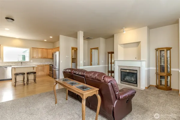 a kitchen with granite countertop stainless steel appliances a refrigerator a stove a sink and white cabinets with wooden floor