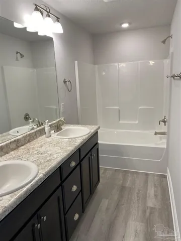a bathroom with a granite countertop sink a toilet and bathtub