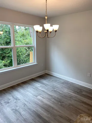 a view of a room with wooden floor exposed radiator and windows