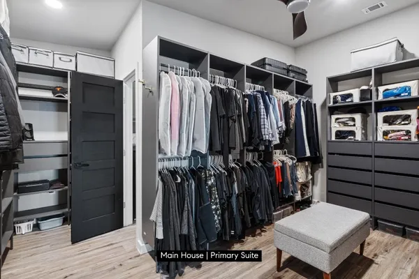 a view of walk in closet with clothes and shoes