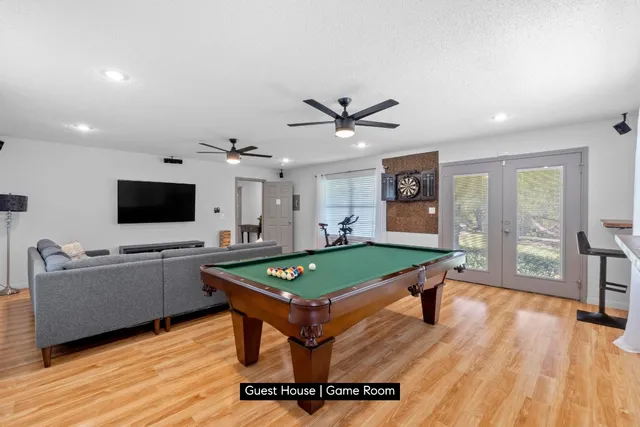 a living room with furniture pool table and a flat screen tv