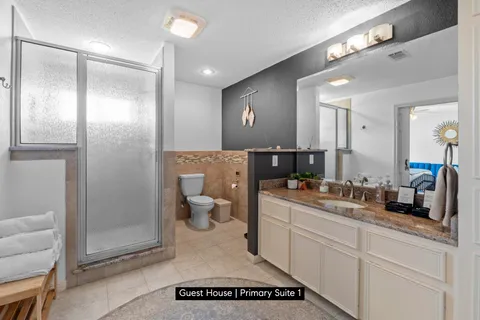 a spacious bathroom with a shower a sink and a mirror