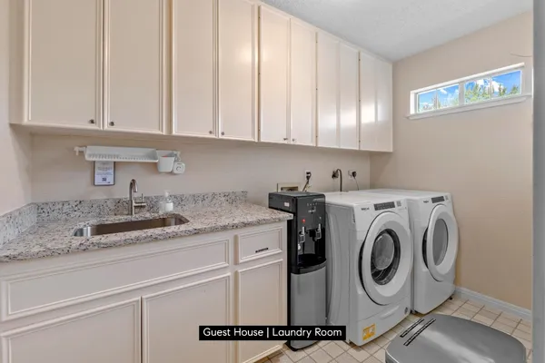 a utility room with sink dryer and washer