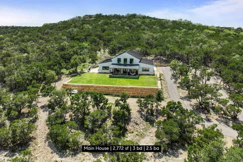 a view of a house with a yard and a forest