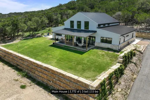 a aerial view of a house with a yard table and chairs