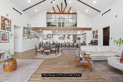 a living room with furniture a table and a large window