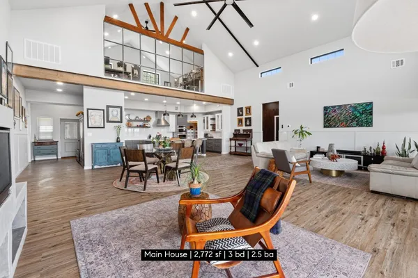 a living room with furniture a rug and kitchen view