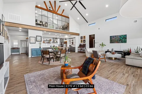 a living room with furniture a rug and kitchen view
