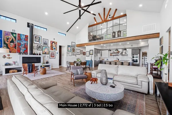 a living room with furniture kitchen view and a large window