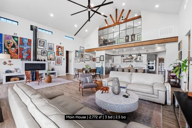 a living room with furniture kitchen view and a large window