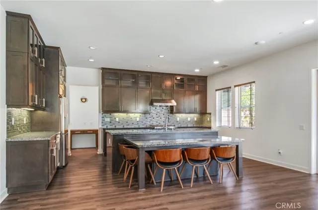 a kitchen with granite countertop and wooden floor